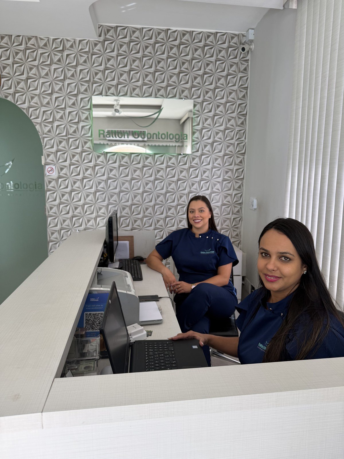 Recepcionistas da Ratton Odontologia no balcão de atendimento