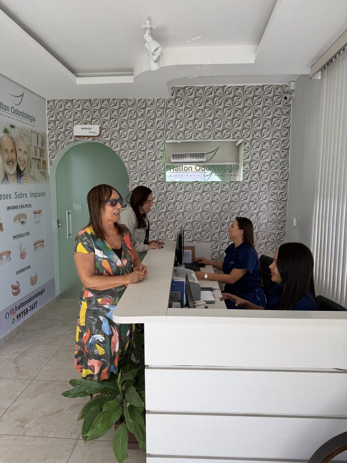 Equipe da recepção da Ratton Odontologia atendendo pacientes